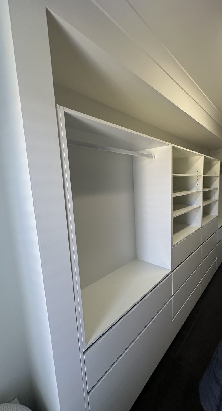 Walk-in wardrobe run with hanging space, open shelving and deep drawers