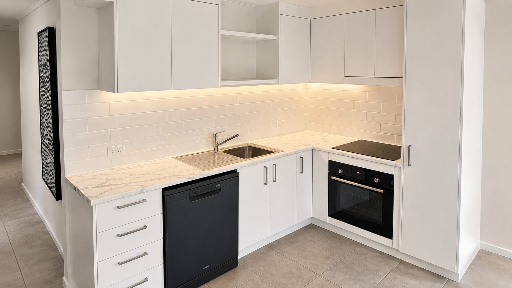 A finished Cab Co. kitchen: white cabinetry, marble benchtop and a tiled splashback